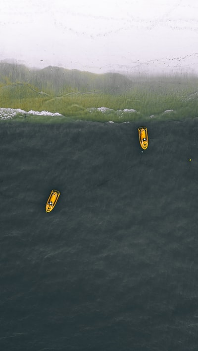 两个黄色个人船只在水面上
